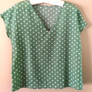 Green and white polka dot polyester women’s blouse.
